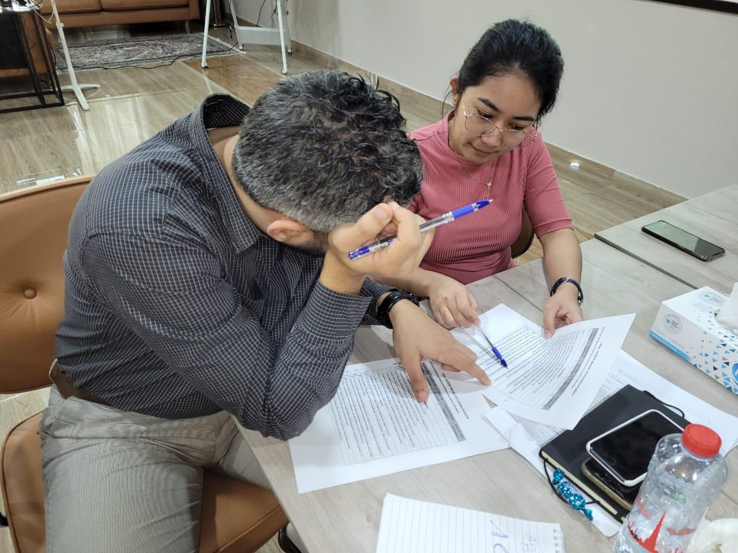 Two colleagues working through a written exercise together